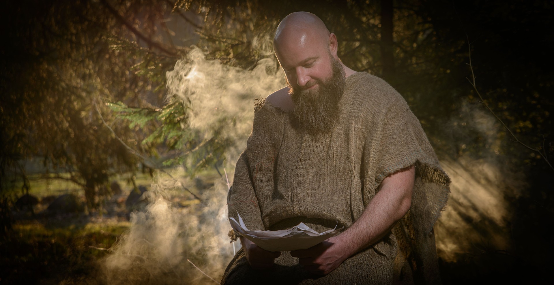 Man in canvas clothes reading a manuscript